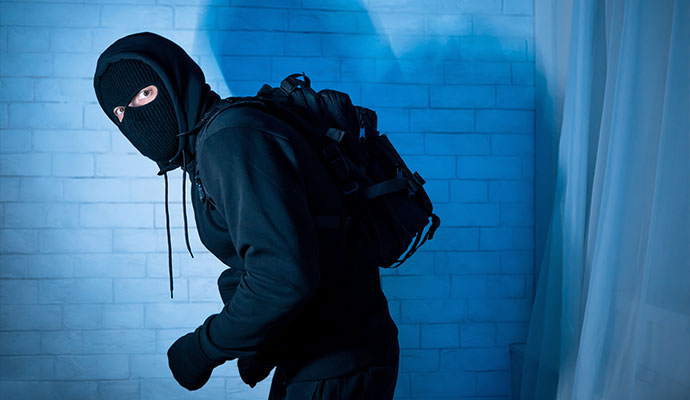 Burglar wearing mask and backpack intruder