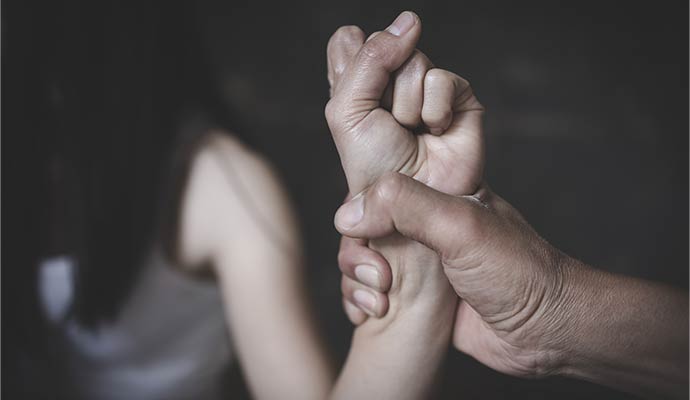 A close-up of a person's hand tightly gripping another person's wrist