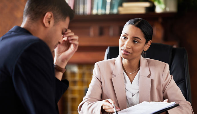 Professional woman consulting with a man during a meeting and reviewing documents