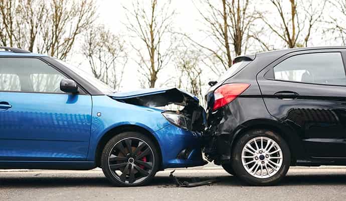 Rear-end collision between two cars with visible front and rear damage